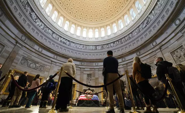 Guests pay their respects as the flag-draped casket of former President Jimmy Carter lies in state at the U.S. Capitol, Wednesday, Jan. 8, 2025, in Washington. Carter died Dec. 29 at the age of 100. (AP Photo/Steve Helber)