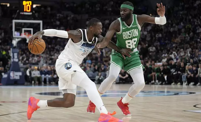 Minnesota Timberwolves forward Julius Randle (30) works toward the basket as Boston Celtics center Neemias Queta (88) defends during the first half of an NBA basketball game, Thursday, Jan. 2, 2025, in Minneapolis. (AP Photo/Abbie Parr)