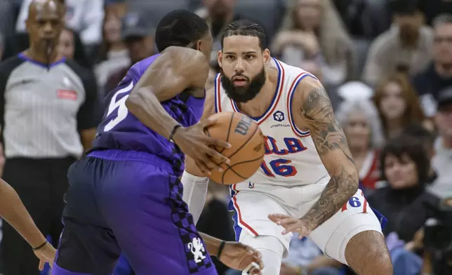 Sacramento Kings guard De'Aaron Fox (5) is guarded by Philadelphia 76ers forward Caleb Martin (16) during the first half of an NBA basketball game in Sacramento, Calif., Wednesday, Jan. 1, 2025. (AP Photo/Randall Benton)