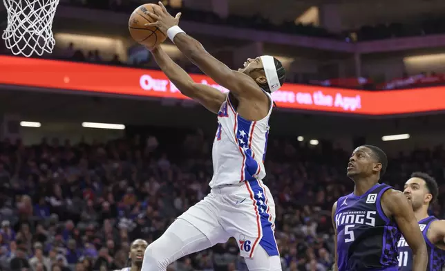 Philadelphia 76ers guard Ricky Council IV drives to the basket past Sacramento Kings guard De'Aaron Fox (5) during the first half of an NBA basketball game in Sacramento, Calif., Wednesday, Jan. 1, 2025. (AP Photo/Randall Benton)