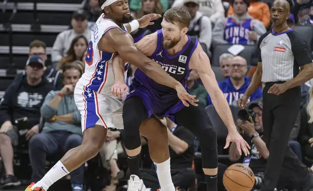 Philadelphia 76ers forward Guerschon Yabusele, left, guards Sacramento Kings forward Domantas Sabonis during the first half of an NBA basketball game in Sacramento, Calif., Wednesday, Jan. 1, 2025. (AP Photo/Randall Benton)