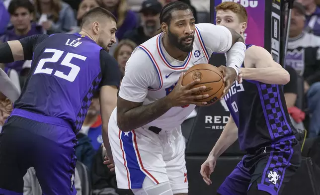 Philadelphia 76ers center Andre Drummond battles for a rebound with Sacramento Kings center Alex Len (25) and Kevin Huerter during the first half of an NBA basketball game in Sacramento, Calif., Wednesday, Jan. 1, 2025. (AP Photo/Randall Benton)