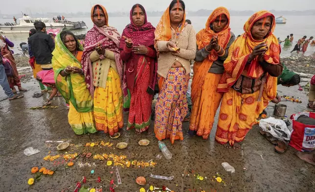 Hindu pilgrims perform rituals after taking a holy dip at Hooghly River on the auspicious occasion of Makar Sankranti, in Kolkata, India, Tuesday, Jan. 14, 2025. (AP Photo/Bikas Das)