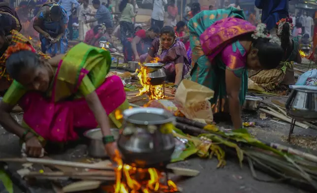 Tamil women cook special food to celebrate the harvest festival of Pongal at Dharavi, one of the Asia's largest slums, in Mumbai, India, Tuesday, Jan. 14, 2025. (AP Photo/Rafiq Maqbool)