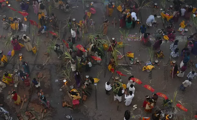 Tamil women cook special food to celebrate the harvest festival of Pongal at Dharavi, one of the Asia's largest slums, in Mumbai, India, Tuesday, Jan. 14, 2025. (AP Photo/Rafiq Maqbool)