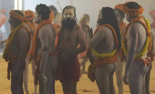 Naked Hindu holy men or a Naga Sadhus of Maharirwani Akhara gets ready at their camp for a dip at Sangam, the confluence of the Rivers Ganges, Yamuna and mythical Saraswati on one of the most auspicious day Makar Sankranti, for the Maha Kumbh festival, which is one of the world's largest religious gatherings, celebrated every 12 years in Prayagraj, in the northern Indian state of Uttar Pradesh, India, Tuesday, Jan. 14, 2025. (AP Photo/Rajesh Kumar Singh)