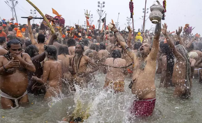 Hindu ascetics and holy men bathe at the confluence of the Ganges, the Yamuna and the mythical Saraswati rivers on the second day of the 45-day-long Maha Kumbh festival in Prayagraj, India, Tuesday, Jan. 14, 2025. (AP Photo/Ashwini Bhatia)