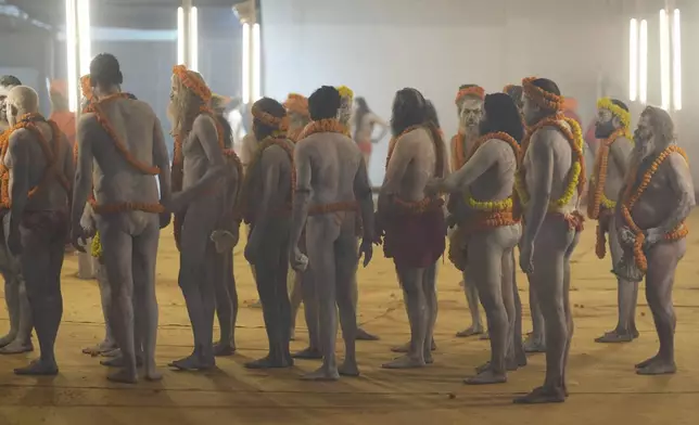 Naked Hindu holy men or a Naga Sadhus of Maharirwani Akhara gets ready at their camp for a dip at Sangam, the confluence of the Rivers Ganges, Yamuna and mythical Saraswati on one of the most auspicious day Makar Sankranti, for the Maha Kumbh festival, which is one of the world's largest religious gatherings, celebrated every 12 years in Prayagraj, in the northern Indian state of Uttar Pradesh, India, Tuesday, Jan. 14, 2025. (AP Photo/Rajesh Kumar Singh)
