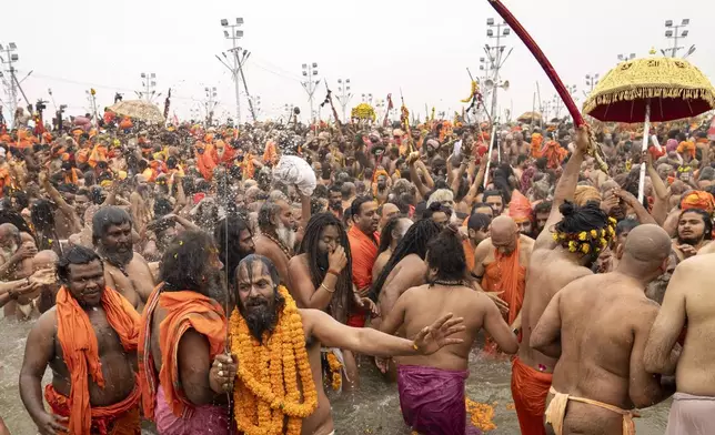 Hindu ascetics and holy men bathe at the confluence of the Ganges, the Yamuna and the mythical Saraswati rivers on the second day of the 45-day-long Maha Kumbh festival in Prayagraj, India, Tuesday, Jan. 14, 2025. (AP Photo/Ashwini Bhatia)
