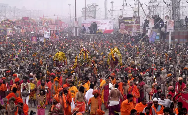 Naga Sadhus of Juna Akhara arrive for ritualistic dip at Sangam, the confluence of the Rivers Ganges, Yamuna and mythical Saraswati on one of the most auspicious day Makar Sankranti, for the Maha Kumbh festival in Prayagraj, India, Tuesday, Jan. 14, 2025. (AP Photo/Rajesh Kumar Singh)