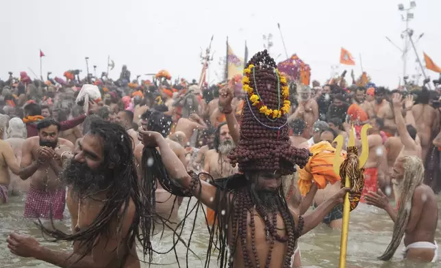 Naga Sadhus, or naked hindu holy men, take holy dips at Sangam, the confluence of the Rivers Ganges, Yamuna and mythical Saraswati on one of the most auspicious day Makar Sankranti, for the Maha Kumbh festival in Prayagraj, India, Tuesday, Jan. 14, 2025. (AP Photo/Rajesh Kumar Singh)