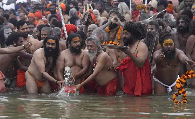 Naga Sadhus of Juna Akhara perform rituals at Sangam, the confluence of the Rivers Ganges, Yamuna and mythical Saraswati on one of the most auspicious day Makar Sankranti, for the Maha Kumbh festival in Prayagraj, India, Tuesday, Jan. 14, 2025. (AP Photo/Rajesh Kumar Singh)