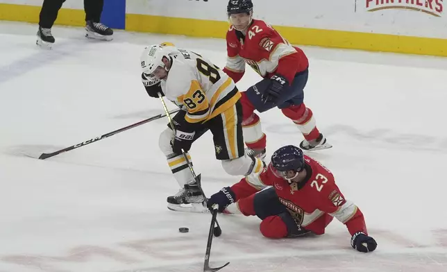 Florida Panthers center Carter Verhaeghe (23) and defenseman Gustav Forsling (42) defend Pittsburgh Penguins left wing Matt Nieto (83) during the second period of an NHL hockey game, Friday, Jan. 3, 2025, in Sunrise, Fla. (AP Photo/Marta Lavandier)