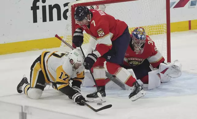 Florida Panthers defenseman Dmitry Kulikov (7) defends a shot by Pittsburgh Penguins right wing Bryan Rust (17) during the second period of an NHL hockey game, Friday, Jan. 3, 2025, in Sunrise, Fla. (AP Photo/Marta Lavandier)