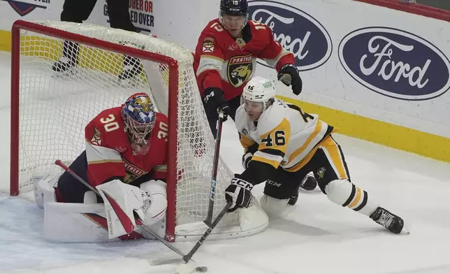 Florida Panthers goaltender Spencer Knight (30) stops a shot by Pittsburgh Penguins center Blake Lizotte (46) during the first period of an NHL hockey game, Friday, Jan. 3, 2025, in Sunrise, Fla. (AP Photo/Marta Lavandier)