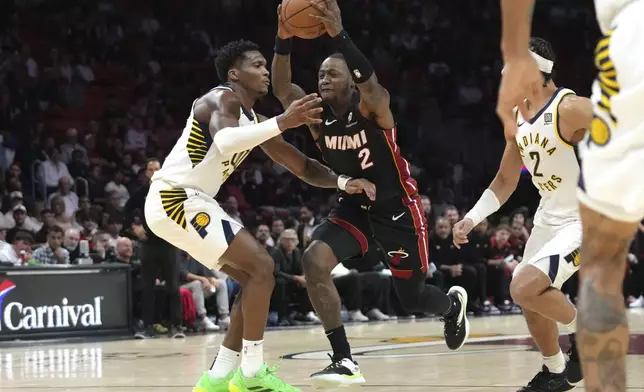 Miami Heat guard Terry Rozier (2) drives to the basket and is ford by Indiana Pacers guard Bennedict Mathurin, left, during the first half of an NBA basketball game Thursday, Jan. 2, 2025, in Miami. (AP Photo/Lynne Sladky)