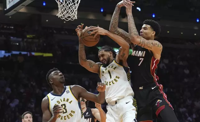 Indiana Pacers center Thomas Bryant (3) and forward Obi Toppin (1) defend against Miami Heat center Kel'el Ware (7) during the first half of an NBA basketball game Thursday, Jan. 2, 2025, in Miami. (AP Photo/Lynne Sladky)