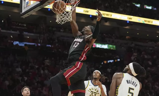 Miami Heat center Bam Adebayo (13) dunks over Indiana Pacers center Myles Turner (33) and forward Jarace Walker (5) during the first half of an NBA basketball game Thursday, Jan. 2, 2025, in Miami. (AP Photo/Lynne Sladky)