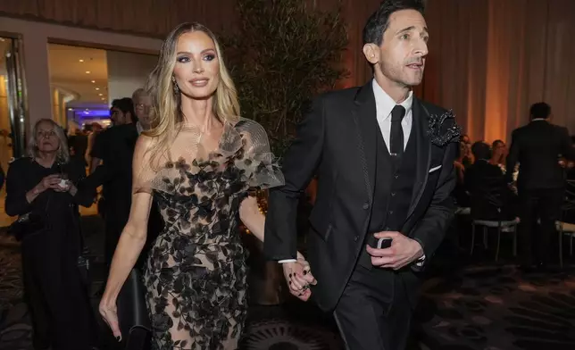 Georgina Chapman, left, and Adrien Brody arrive at the 82nd Golden Globes on Sunday, Jan. 5, 2025, at the Beverly Hilton in Beverly Hills, Calif. (AP Photo/Chris Pizzello)