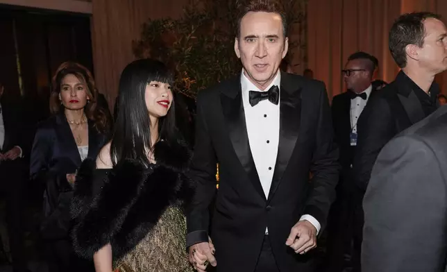 Riko Shibata, left, and Nicolas Cage arrive at the 82nd Golden Globes on Sunday, Jan. 5, 2025, at the Beverly Hilton in Beverly Hills, Calif. (AP Photo/Chris Pizzello)