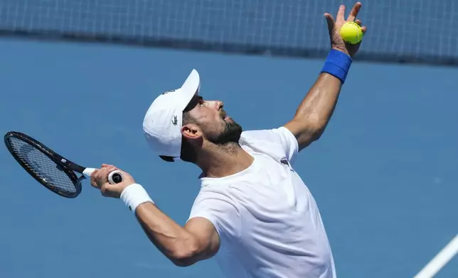 Serbia's Novak Djokovic serves during a practice session ahead of the Australian Open tennis championship in Melbourne, Australia, Saturday, Jan. 11, 2025. (AP Photo/Manish Swarup)