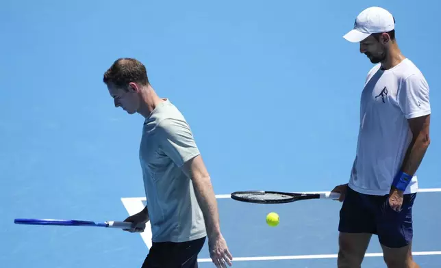 Serbia's Novak Djokovic walks with his coach Andy Murray, left, during a practice session ahead of the Australian Open tennis championship in Melbourne, Australia, Saturday, Jan. 11, 2025. (AP Photo/Ng Han Guan)