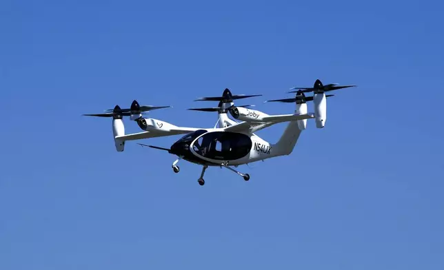 An "electric vertical take-off and landing" aircraft built by Joby Aviation flies over an airfield in Marina, Calif. on Monday, Oct. 7, 2024. (AP Photo/Terry Chea)