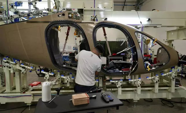 A Joby Aviation employees works on the assembly of an "electric vertical takeoff and landing" eVTOL aircraft in Marina, Calif. on Monday, Oct. 7, 2024. (AP Photo/Terry Chea)