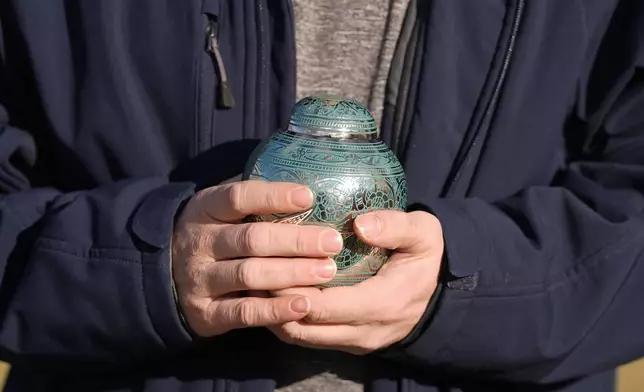 Eric Pranger holds an Urn that contains the ashes of Allen Livingston, Saturday, Dec. 21, 2024, in Westfield, Ind. (AP Photo/Darron Cummings)