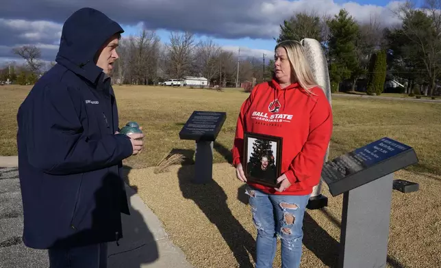 Eric Pranger and Shannon Doughty talk by a memorial, Saturday, Dec. 21, 2024, in Westfield, Ind. (AP Photo/Darron Cummings)