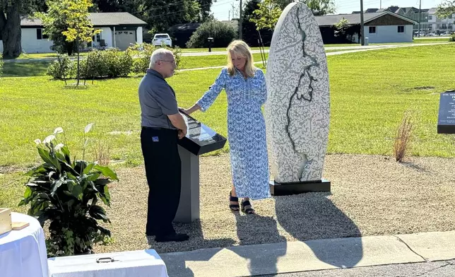 Hamilton County Coroner Jeff Jellison and Linda Znachko, founder of the nonprofit Indianapolis-based ministry He Knows Your Name, look at a marker on August 29, 2024, in Westfield, Indiana, that lists the names of the nine known victims of suspected serial killer Herbert Baumeister. (AP Photo/Rick Callahan)