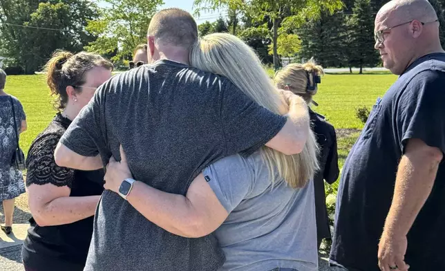 Shannon Doughty and her cousin, Eric Pranger, embrace on Aug. 29, 2024, in Westfield, Indiana, during the dedication of a memorial to the known victims of suspected serial killer Herbert Baumeister, including Doughty's brother, Allen Livingston. (AP Photo/Rick Callahan)