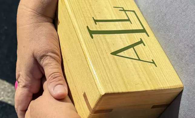 Shannon Doughty holds a wooden box on Aug. 29, 2024, in Westfield, Indiana, that had contained some of the cremated remains of her late brother, Allen Livingston, who was identified in October 2023 as the ninth known victim of suspected serial killer Herbert Baumeister. (AP Photo/Rick Callahan)