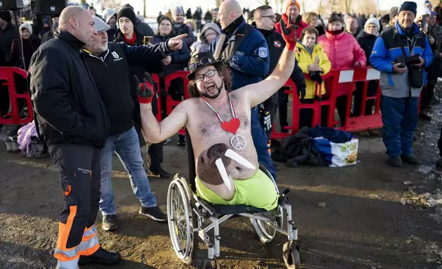 A man gestures as he prepares to take a dip in the icy Tisza Lake near Tiszafured, Hungary, to celebrate the New Year on Saturday, Jan. 4, 2025. (AP Photo/Denes Erdos)