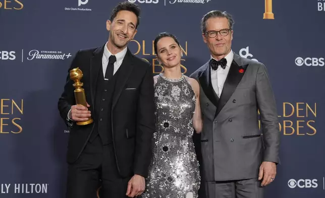 Adrien Brody, winner of the award for best performance by a male actor in a motion picture drama for "The Brutalist", from left, Felicity Jones, and Guy Pearce pose in the press room during the 82nd Golden Globes on Sunday, Jan. 5, 2025, at the Beverly Hilton in Beverly Hills, Calif. (AP Photo/Chris Pizzello)