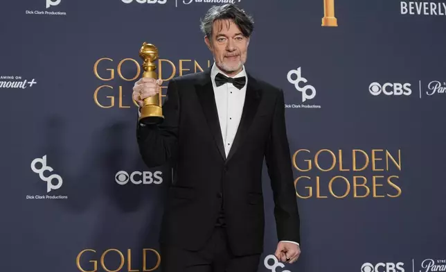 Peter Straughan poses in the press room with the award for best screenplay - motion picture for "Conclave" during the 82nd Golden Globes on Sunday, Jan. 5, 2025, at the Beverly Hilton in Beverly Hills, Calif. (AP Photo/Chris Pizzello)