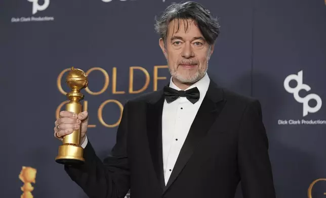 Peter Straughan poses in the press room with the award for best screenplay - motion picture for "Conclave" during the 82nd Golden Globes on Sunday, Jan. 5, 2025, at the Beverly Hilton in Beverly Hills, Calif. (AP Photo/Chris Pizzello)