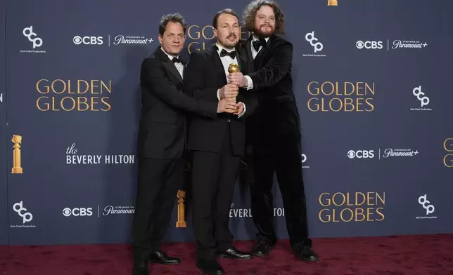 Ron Dyens, from left, Gints Zilbalodis, and Matiss Kaza pose in the press room with the award for best motion picture - animated for "Flow" during the 82nd Golden Globes on Sunday, Jan. 5, 2025, at the Beverly Hilton in Beverly Hills, Calif. (AP Photo/Chris Pizzello)