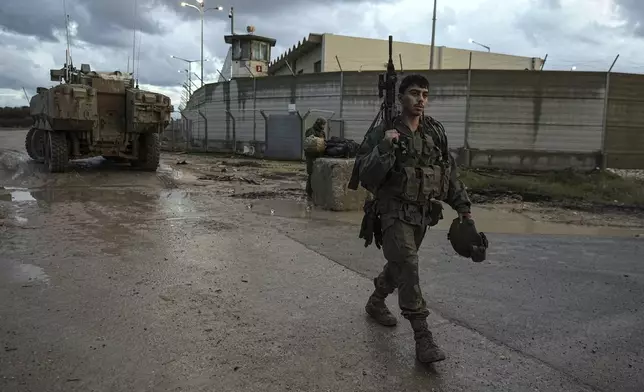 An Israeli soldier walks through a staging area as his unit prepares to enter the Gaza Strip at the Israel-Gaza border in southern Israel on Tuesday, Dec. 31, 2024. (AP Photo/Tsafrir Abayov)