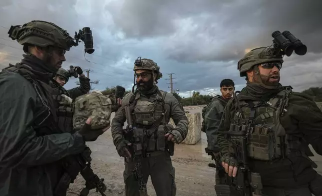 Israeli soldiers prepare to be deployed to the Gaza Strip near the Israeli-Gaza border in southern Israel, Tuesday, Dec. 31, 2024. (AP Photo/Tsafrir Abayov)