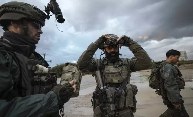 An Israeli soldier adjusts his night vision goggles as his unit prepares to enter the Gaza Strip at the Israel-Gaza border in southern Israel on Tuesday, Dec. 31, 2024. (AP Photo/Tsafrir Abayov)