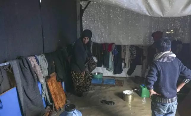 Manal Lubbad, a 49-year-old mother of eight and a displaced woman from Gaza City, tries to clean her flooded tent after heavy overnight rainfall at the refugee tent camp for displaced Palestinians in Deir al-Balah, central Gaza Strip, Tuesday, Dec. 31, 2024. (AP Photo/Abdel Kareem Hana)