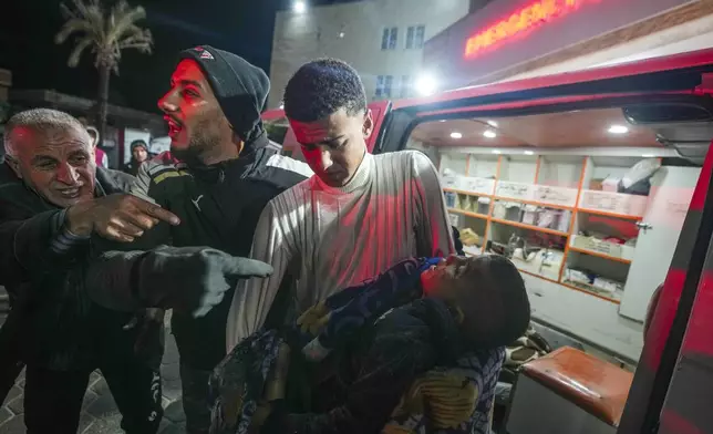 The body of 8-year-old Adam Farajallah is brought to Al-Aqsa Martyrs Hospital following an airstrike on a house in the Bureij refugee camp, in the central Gaza Strip town of Deir al-Balah, Wednesday, Jan. 1, 2025. (AP Photo/Abdel Kareem Hana)