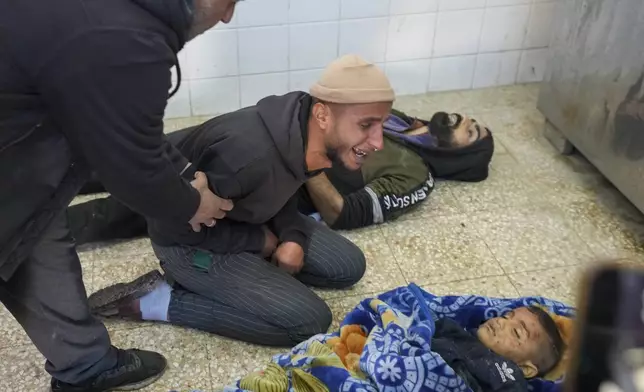 The uncle of 8-year-old Adam Farajallah grieves over his body after it was brought to Al-Aqsa Martyrs Hospital following an airstrike on a house in the Bureij refugee camp, in the central Gaza Strip town of Deir al-Balah Wednesday, Jan. 1, 2025. (AP Photo/Abdel Kareem Hana)