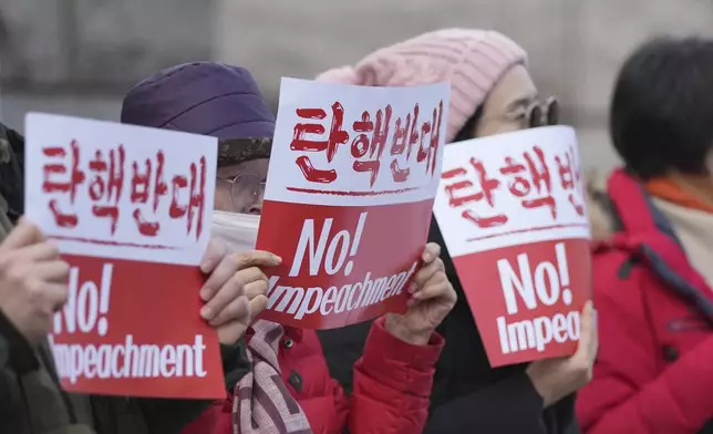 Supporters of impeached South Korean President Yoon Suk Yeol hold signs during a rally to oppose his impeachment outside the Constitutional Court in Seoul, South Korea, Tuesday, Jan. 14, 2025. (AP Photo/Lee Jin-man)