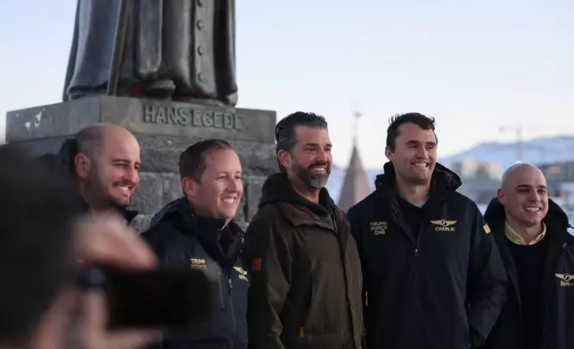 Donald Trump Jr., center, poses for a photo in front of Hans Egede statue as he arrives in Nuuk, Greenland, Tuesday, Jan. 7, 2025. (Emil Stach/Ritzau Scanpix via AP)