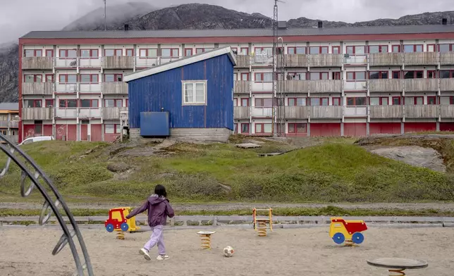 FILE - A child plays in front of a residential block in Sisimiut, Greenland, Tuesday, July 2, 2024. (Ida Marie Odgaard/Ritzau Scanpix via AP, File)