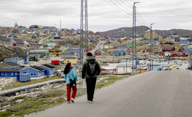 FILE - People walk in the town of Aasiaat, in western Greenland, located on its namesake island in the heart of Aasiaat Archipelago at the southern end of Disko Bay, in Greenland, Saturday, June 29, 2024. (Ida Marie Odgaard/Ritzau Scanpix via AP, File)