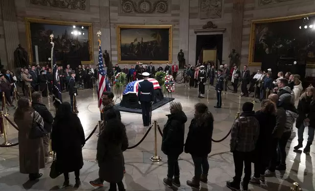 Mourners look at the flag-draped casket of former President Jimmy Carter as he lies in state in the Capitol, Tuesday, Jan. 7, 2025, in Washington. (AP Photo/Jose Luis Magana)