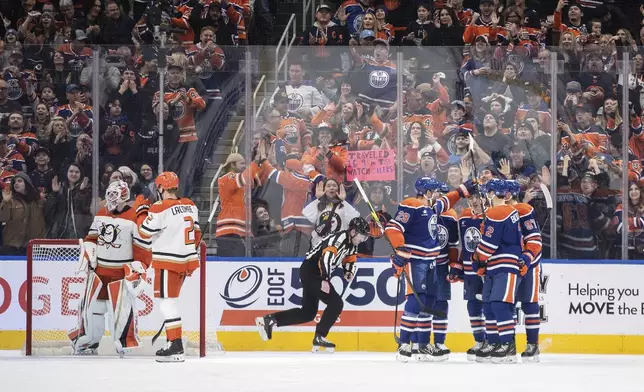 Edmonton Oilers' Leon Draisaitl (29), Zach Hyman (18), Ryan Nugent-Hopkins (93), Evan Bouchard (2) and Connor McDavid (97) celebrate a goal as Anaheim Ducks' goalie Lukas Dostal (1) and Jackson LaCombe (2) look on during the first period of an NHL hockey game in Edmonton, Alberta, Friday, Jan. 3, 2025. (Jason Franson/The Canadian Press via AP)